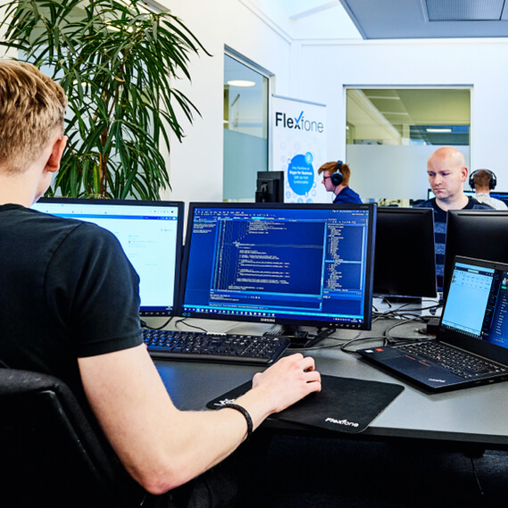 Flexfones kontor hvor medarbejdere arbejder ved computere og programmere